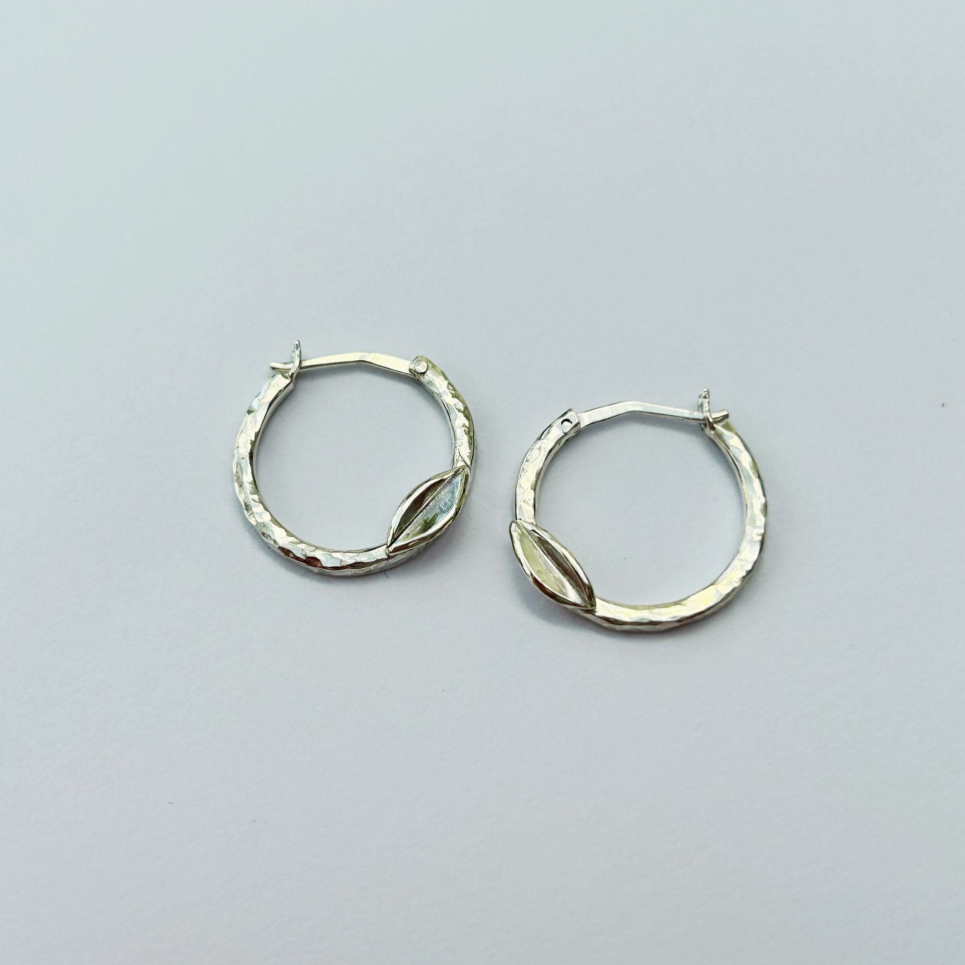 Handcrafted hammered silver hoop earrings with leaf detail – elegant artisan creoles for women
