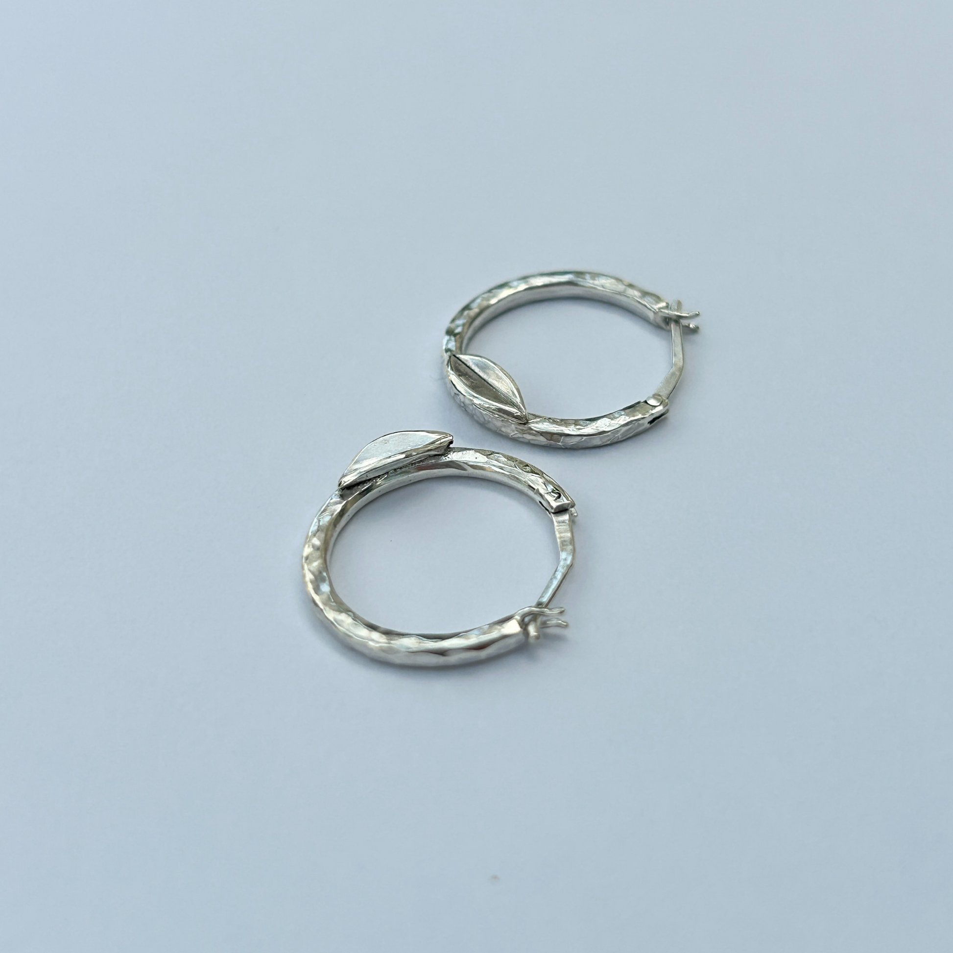 Handcrafted hammered silver hoop earrings with leaf detail – elegant artisan creoles for women