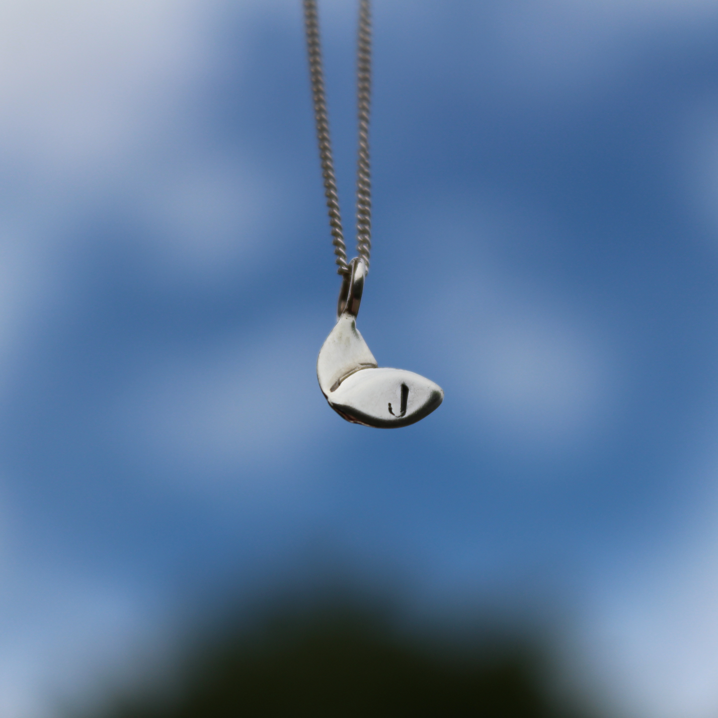 a personalised silver leaf necklace with a hand stamped 'J' with sky background - handmade by Jen Lithgo Jewellery