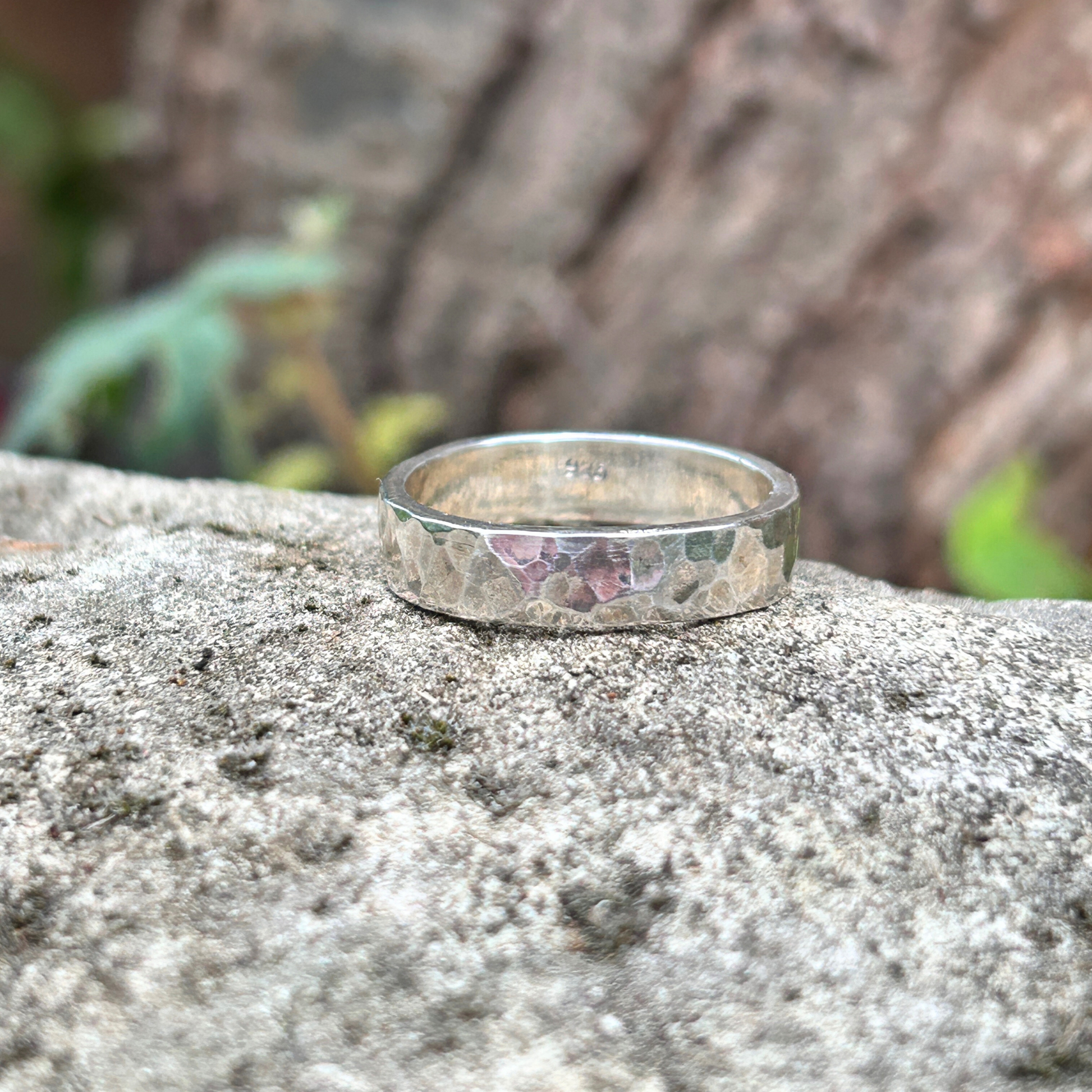 Sterling Silver ring with a textured band on a stone surface with a natural background