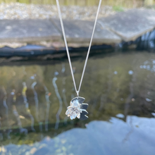 Load image into Gallery viewer, Water lily flower sat on three lily pads hanging on a curb chain over a pomnd, handmade in sterling silver by Jen Lithgo Jewellery