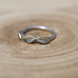 three leaf silver ring on wooden background