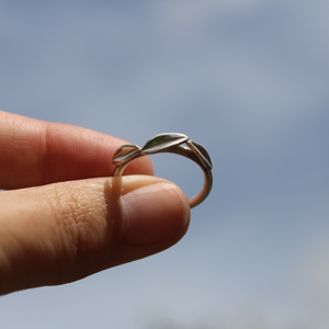 three leaf ring held against a sky backdrop