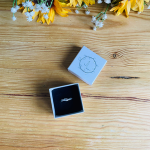 three leaf ring in ivory box on wooden table top