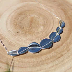 Bridesmaid 7 leaf silver necklace on wooden background