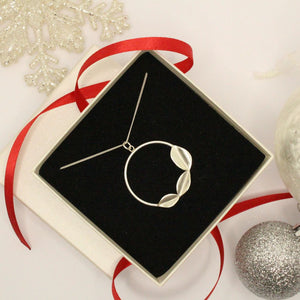 Sterling silver geometric leaf necklace in a gift box with red ribbon and christmas decorations handmade by Jen Lithgo Jewellery