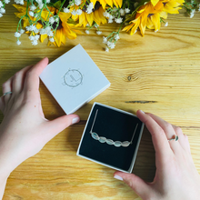 Load image into Gallery viewer, Scatter five leaf necklace handmade from sterling silver in a branded box held by ladies hands by Jen Lithgo Jewellery