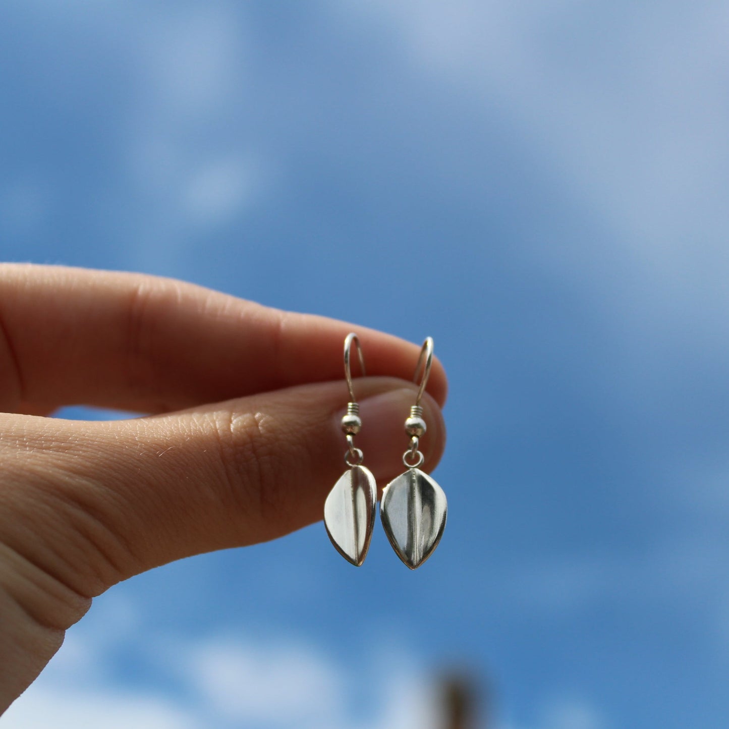 Small Leaf Drop Earrings being held by a womans hand - handmade in Sterling Silver by Jen Lithgo Jewellery