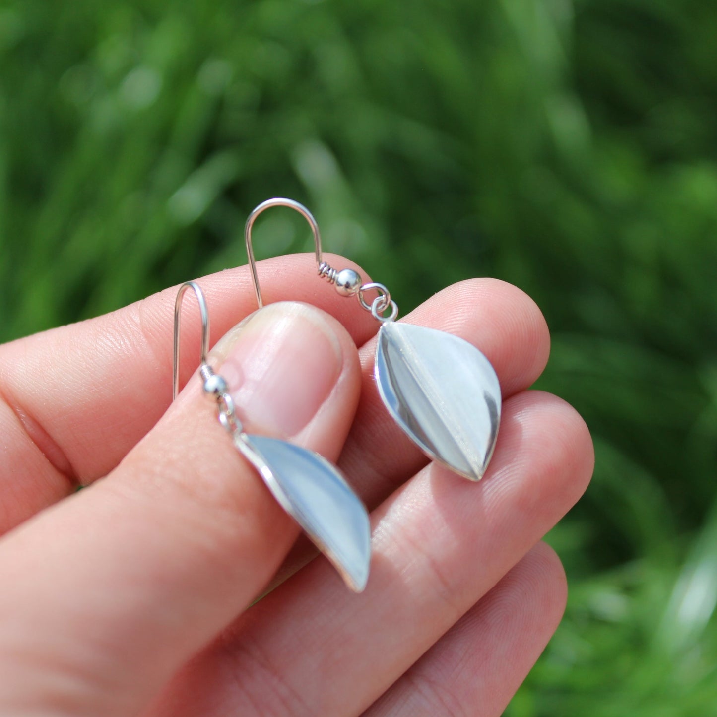 Handmade Large Leaf drop earrings held by a woman's hand - handmade by Jen Lithgo Jewellery