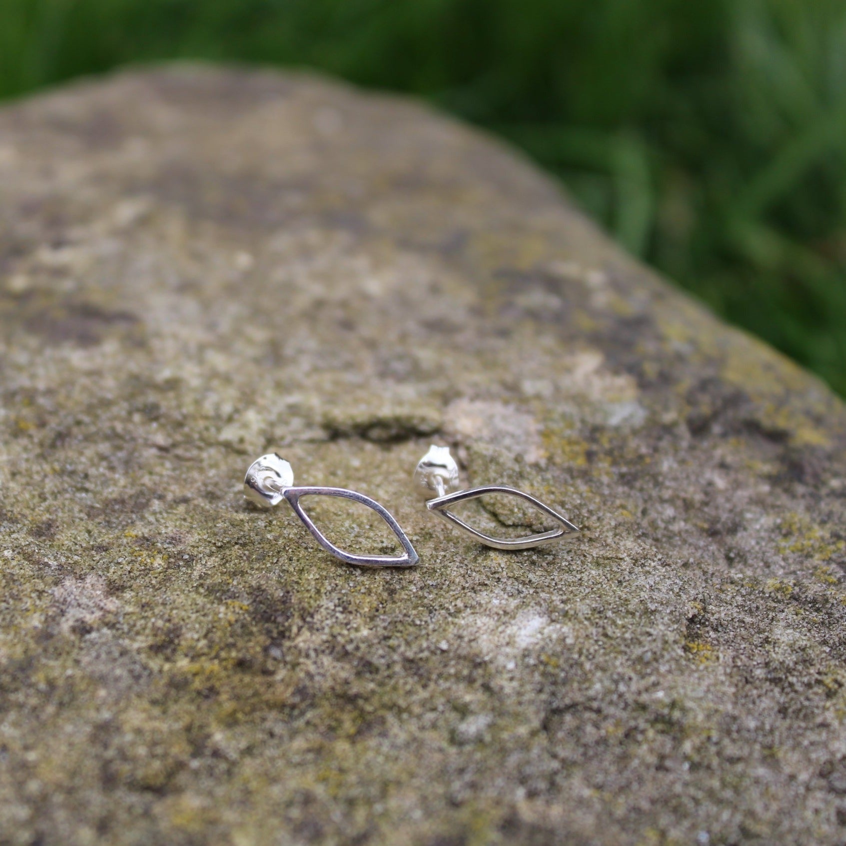 Handmade Silhouette outline leaf stud earrings made from sterling silver with butterfly scroll back sat on a rock - handmade by Jen Lithgo Jewellery Designer