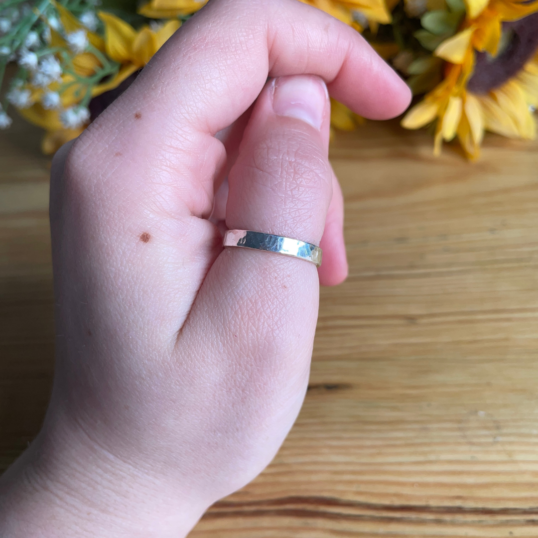 Hammered 4mm ring in sterling silver being worn on a womans thumb / hand - handmade by Jen Lithgo Jewellery